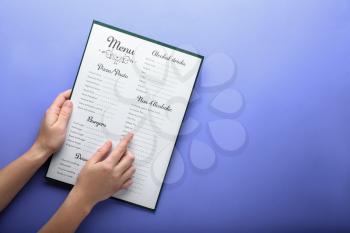 Female hands with menu on color background�