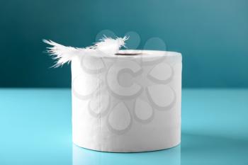 Roll of toilet paper and soft feather on color table�