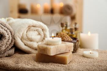 Beautiful spa composition with soap and candles on table�