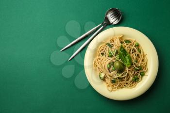 Plate with tasty pasta on color background�