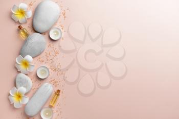 Spa composition with stones, flowers and candles on light background�