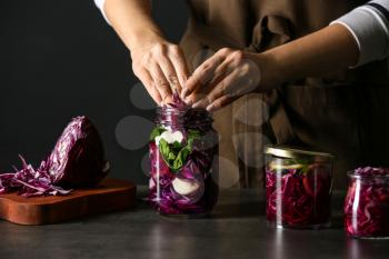 Woman preparing fresh cabbage for fermentation on table�