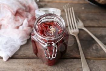 Jar with tasty fermented beetroot on wooden table�