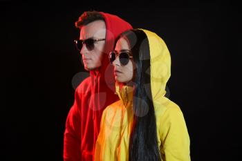 Toned portrait of stylish young couple on dark background�