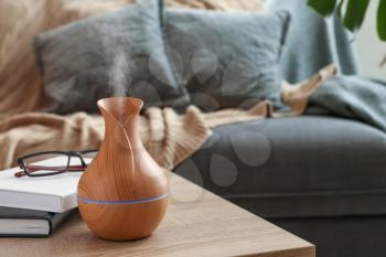 Aroma oil diffuser on table in room�