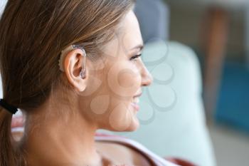Young woman with hearing aid at home�