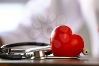 Heart with stethoscope on table of doctor, closeup�