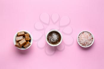 Tasty candies with caramel and salt on color background�