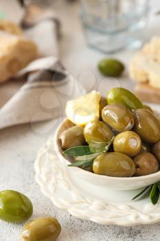 Bowl with tasty olives on grey background�