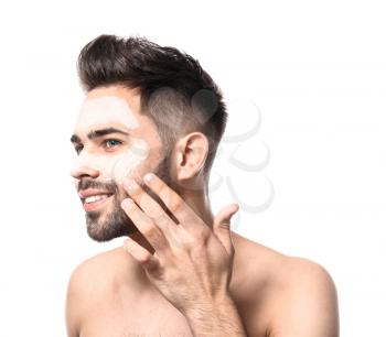 Handsome man with clay mask on his face against white background�