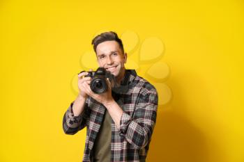 Young male photographer on color background�