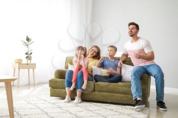 Happy family watching TV at home�