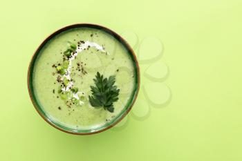 Bowl of tasty cream soup on color background�