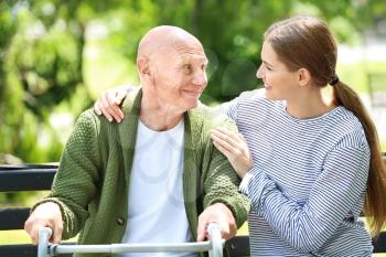 Elderly man with his daughter in park�