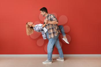 Portrait of dancing couple near color wall�