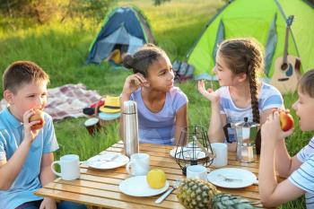 Group of children having picnic outdoors on summer day�