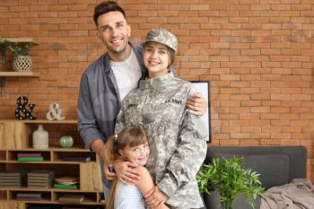 Happy female soldier with her family at home�