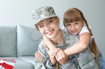 Happy female soldier with her daughter at home�