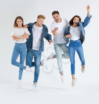Group of jumping young people in stylish casual clothes on white background�
