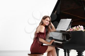 Beautiful young woman at grand piano�