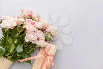 Gift box and beautiful flowers on light background�
