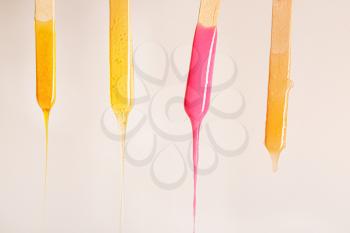 Sticks with dripping sugaring paste on light background�
