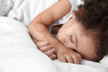 Little African-American girl sleeping in bed�