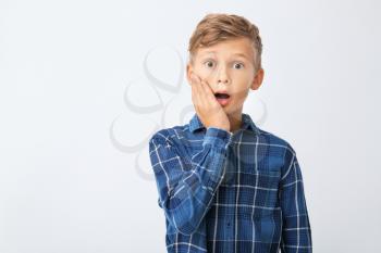 Surprised little boy on white background�