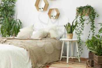 Stylish interior of bedroom with green houseplants�