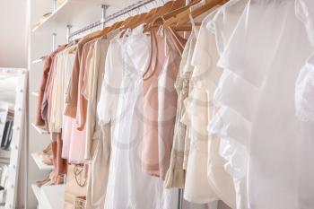 Stylish clothes on hangers in show room�