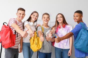 Cool teenagers showing thumb-up on white background�