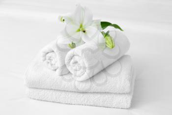 Clean soft towels and flowers on bed�