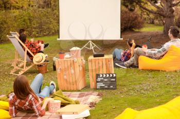 Friends watching movie in outdoor cinema�