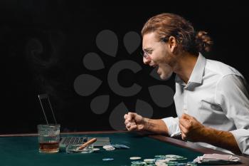 Emotional young man playing poker online�