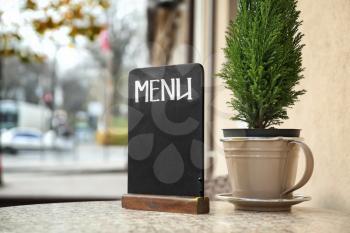 Empty menu board on table in outdoor cafe�