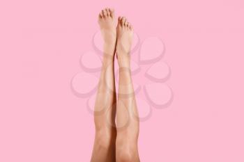 Legs of beautiful young woman on color background�