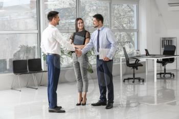 Bank manager shaking hands with couple in office�