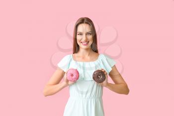 Funny young woman with donuts on color background�