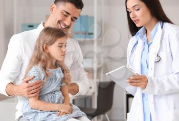 Man with little daughter visiting pediatrician in clinic�