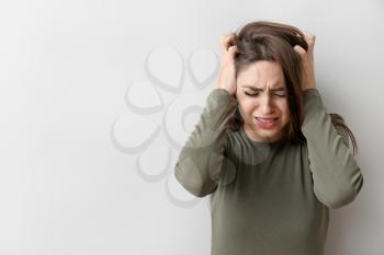Depressed young woman on light background�