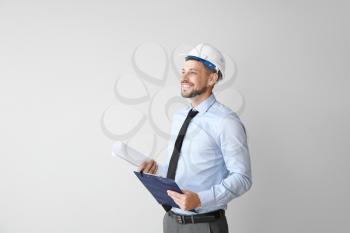 Male engineer with drawing on light background�