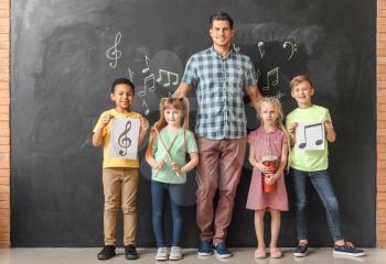 Music teacher with little children at school�