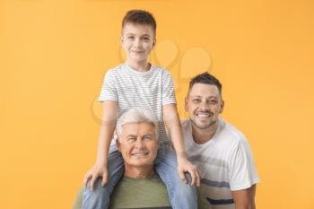 Man with his father and son on color background�