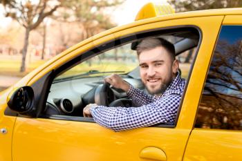 Portrait of handsome driver in taxi car�