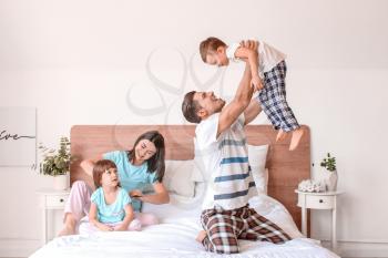 Happy family having fun in bedroom at home�