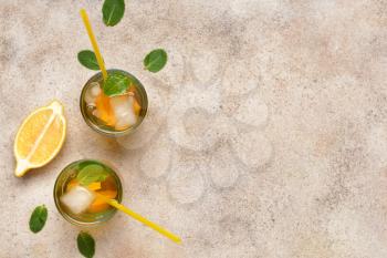 Glasses of tasty cold ice tea on grey background�