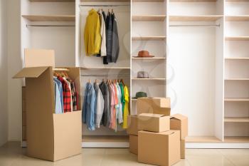 Moving boxes near wardrobe in dressing room�