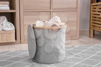 Laundry basket with dirty towels on floor in room�