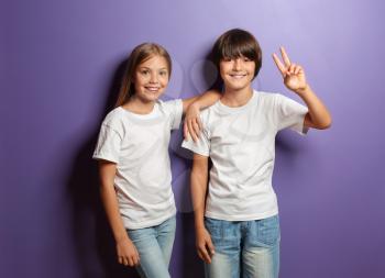 Cute little children in t-shirts on color background�