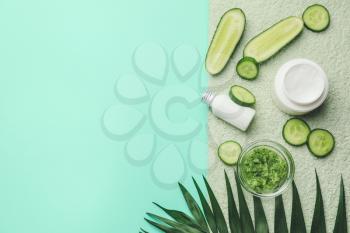 Composition with cucumber and cosmetics on color background�